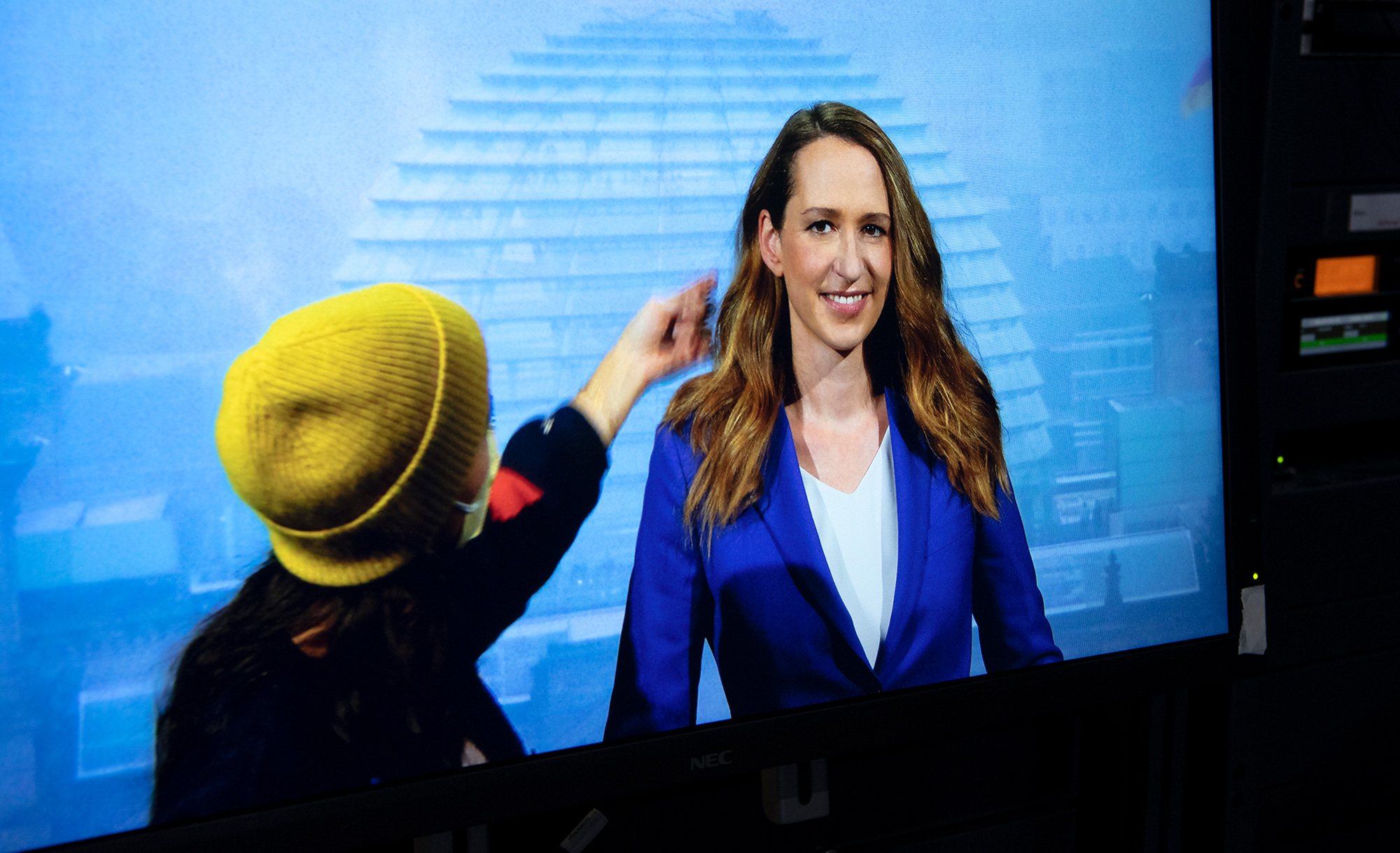 Nachrichtensprecherin auf einem Bildschirm im Studio (Foto)